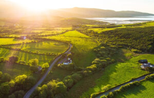 Beste Reisezeit Irland auf der grünen Insel leuchtet die Sonne über grünen Feldern.